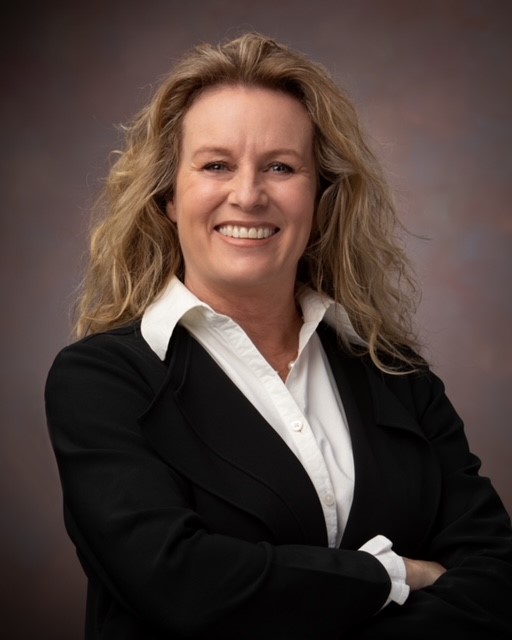 white woman in a black blazer on a gray background